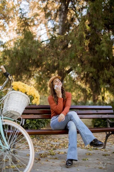 Hübsche Junge Frau Telefoniert Herbstpark Auf Bank Fahrrad — Stockfoto