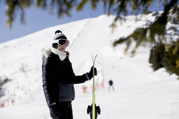 愉快的年轻妇女与滑雪设备在山度假村度过寒假 — 图库照片