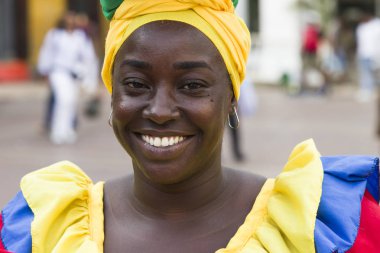 CARTAGENA, COLOMBIA - SEPTEMBER 16, 2019: Unidentified palenquera, fruit seller lady on the street of Cartagena, Colombia. These Afro-Colombian women come from village San Basilio de Palenque, just outside the city. clipart