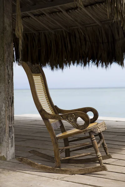 Karayip deniz kıyısındaki eski ahşap salıncak sandalyesine bakın.