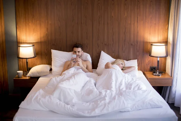 Hombre Usando Teléfono Móvil Mientras Esposa Duerme Cama Casa — Foto de Stock
