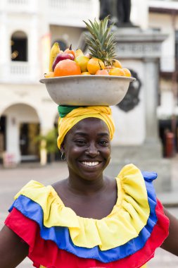 Cartagena, Kolombiya - 16 Eylül 2019: tanımlanamayan palenquera, Cartagena, Kolombiya sokaklarındaki meyve satıcısı kadın. Bu Afro-Kolombiyalı kadınlar şehrin hemen dışındaki San Basilio de Palenque köyünden geliyorlar..