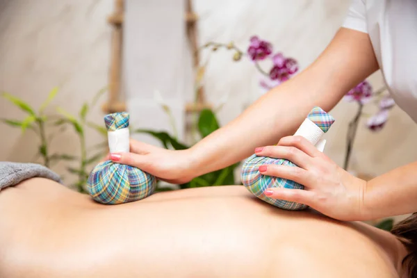 Rustige Jonge Vrouw Genieten Van Massage Met Kruidenzakken Spa — Stockfoto
