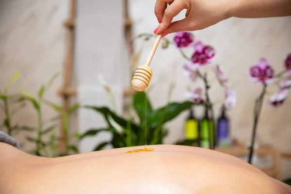 Jonge Vrouw Met Een Honing Terug Massage Spa Salon — Stockfoto