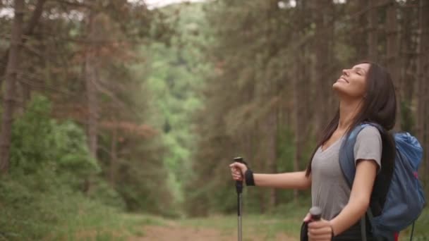 Mujer joven extendiendo los brazos y disfrutando de los viajes de mochilero en el bosque — Vídeo de stock