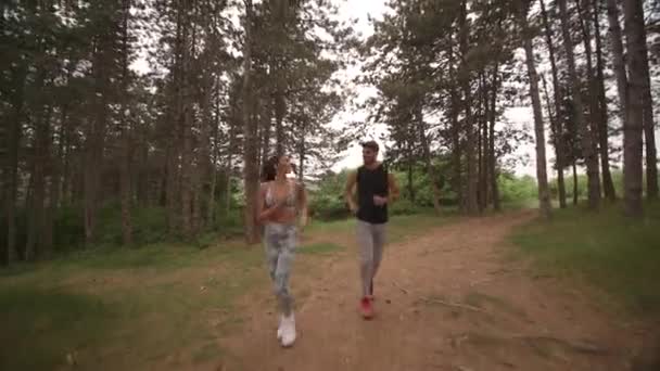 Young fitness couple running at the forest trail — Stock Video