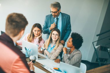 Modern ofiste yeni bir proje üzerinde çalışan çok ırklı iş adamları grubu