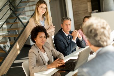 Modern ofiste yeni bir proje üzerinde çalışan çok ırklı iş adamları grubu