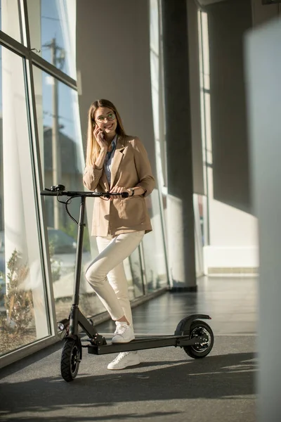 Jolie Jeune Femme Debout Près Fenêtre Bureau Avec Scooter Électrique — Photo