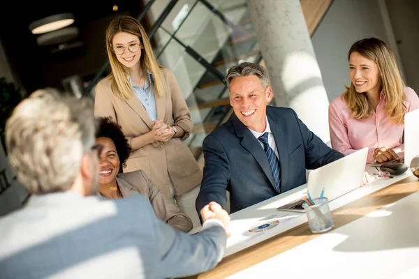 Gente Negocios Dándose Mano Mientras Están Sentados Junto Escritorio Oficina — Foto de Stock