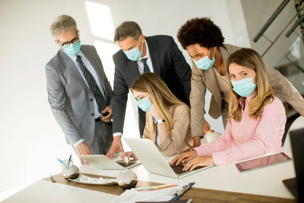 Group business people have a meeting and working in the office and wear masks as protection from corona virus