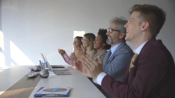Skupina podnikatelů tleská po úspěšném obchodním setkání v moderní kanceláři — Stock video