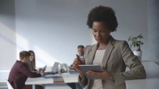Erfolgreiche schwarze afroamerikanische Geschäftsfrau arbeitet mit digitalem Tablet im modernen Büro — Stockvideo