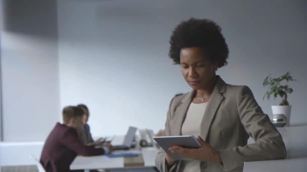 Erfolgreiche schwarze afroamerikanische Geschäftsfrau arbeitet mit digitalem Tablet im modernen Büro — Stockvideo