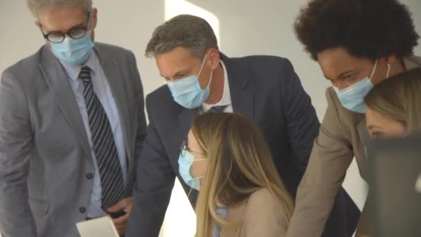 Grupp av affärsmän har ett möte och arbetar på kontoret och bär masker som skydd mot koronavirus — Stockvideo