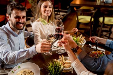 Bir grup genç restoranda yemek yiyor.