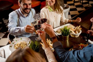 Bir grup genç restoranda yemek yiyor.