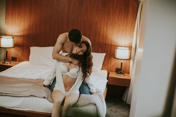 Yatak Odasındaki Yatakta Oturan Sevgi Dolu Sarılan Genç Çift — Stok fotoğraf