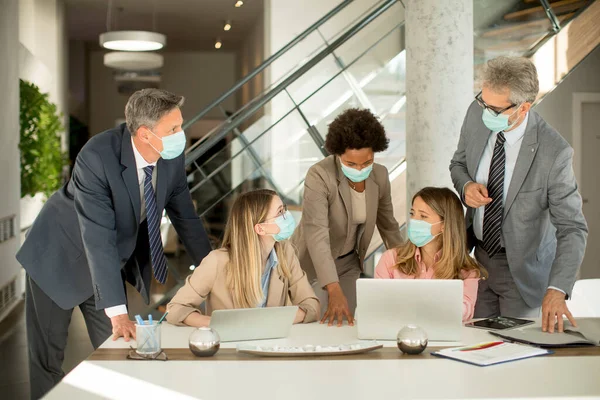 Group of business people have a meeting and working in the office and wear masks as protection from corona virus