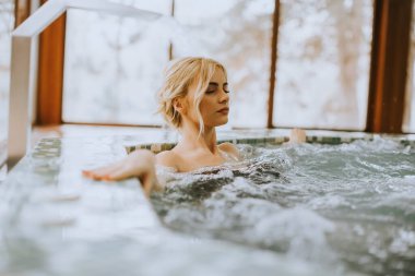 Güzel genç bayan girdap havuzunda dinleniyor.