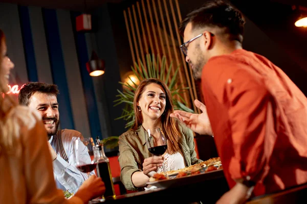 Group of young people having dinner in the restaurant