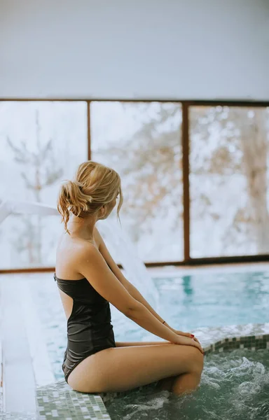 漂亮的年轻女子坐在漩涡浴缸边放松 — 图库照片