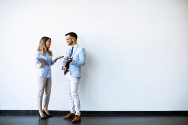 Ofisin duvarında dijital tabletleri olan gençler