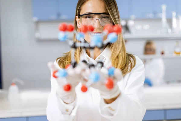 Vrouwelijke Chemicus Met Veiligheidsbril Houden Moleculair Model Het Lab — Stockfoto