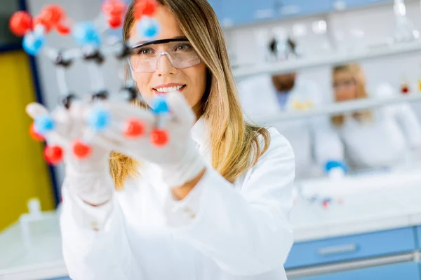 Γυναίκα Χημικός Γυαλιά Ασφαλείας Κρατήσει Μοριακό Μοντέλο Στο Εργαστήριο — Φωτογραφία Αρχείου
