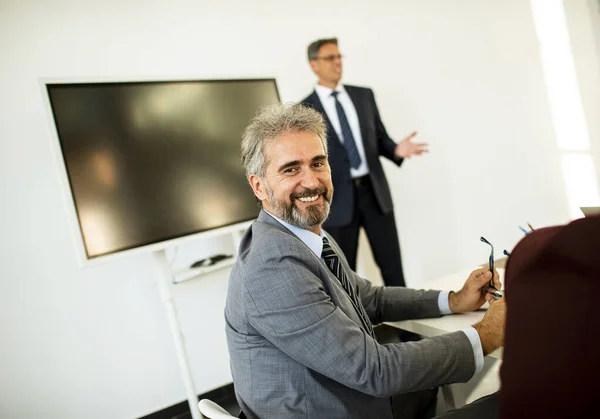 Schöner Reifer Geschäftsmann Sitzt Tisch Während Seine Partner Die Geschäftsergebnisse — Stockfoto