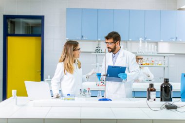 Araştırmacılar laboratuvardaki ayrıştırıcı hunide mavi sıvıyla çalışıyorlar.