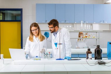 Araştırmacılar laboratuvardaki ayrıştırıcı hunide mavi sıvıyla çalışıyorlar.