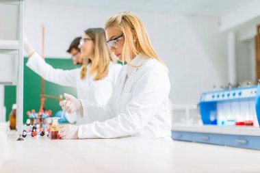 Laboratuvarda kimyasal verileri analiz eden genç araştırmacılar.