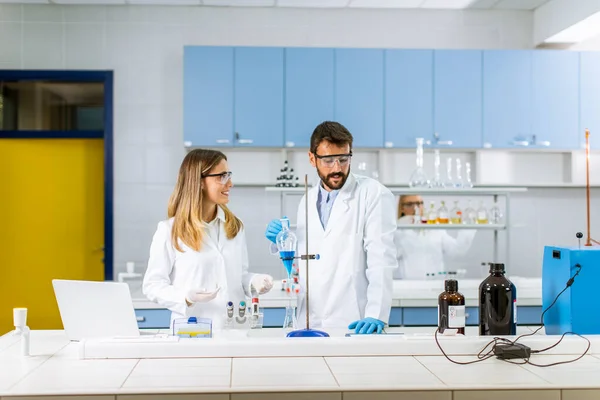 Onderzoekers Die Het Laboratorium Werken Met Blauwe Vloeistof Afscheidingstrechter — Stockfoto