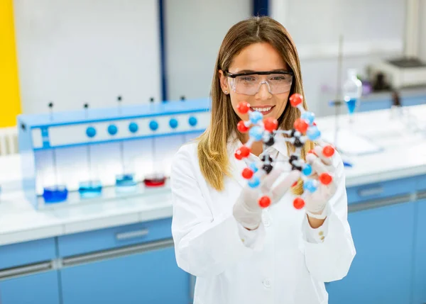 Vrouwelijke Chemicus Met Veiligheidsbril Houden Moleculair Model Het Lab — Stockfoto