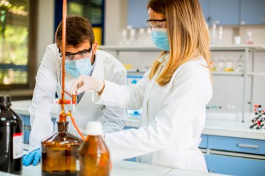 Laboratuvarda kimyasal verileri analiz eden genç araştırmacılar.