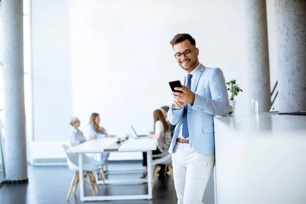 Happy Young Man Using His Mobile Phone Office Smiling While — Stock Photo, Image