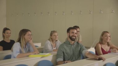 Üniversite sınıfında oturan genç öğrenciler