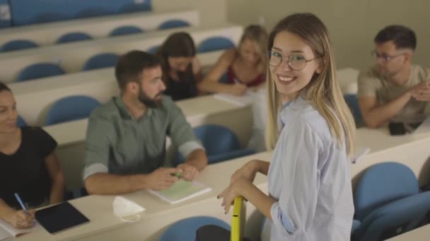 Joven profesora grupo docente de jóvenes estudiantes en el aula universitaria — Vídeos de Stock