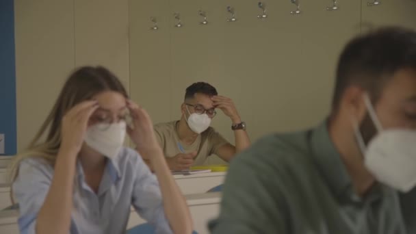 坐在大学教室里戴口罩的年轻学生是为了防止感染病毒 — 图库视频影像