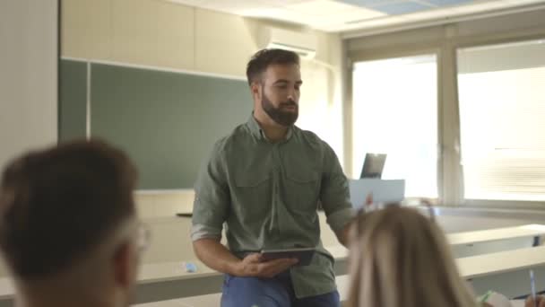 Fiatal férfi oktató csoport fiatal diákok az egyetemi osztályteremben — Stock videók