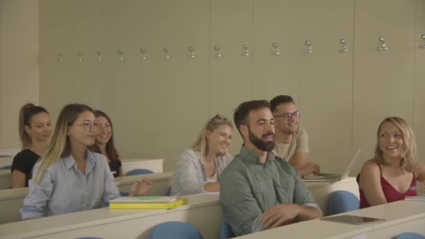 Junge Studenten sitzen im Hörsaal der Universität — Stockvideo