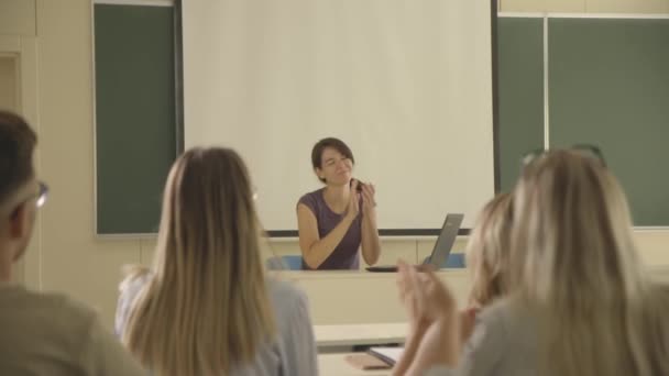 Jonge vrouwelijke docent onderwijsgroep van jonge studenten in de klas van de universiteit — Stockvideo