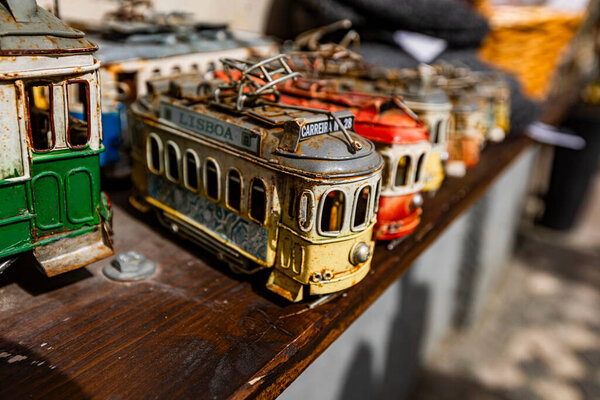 Lisbon, Portugal - February 17, 2025: Colorful model trams at a Lisbon market. Tram 28 is particularly famous for its scenic route, passing historic districts like Alfama and Baixa