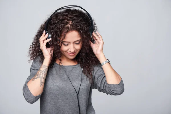 Vrouw luisterend naar muziek in hoofdtelefoon — Stockfoto