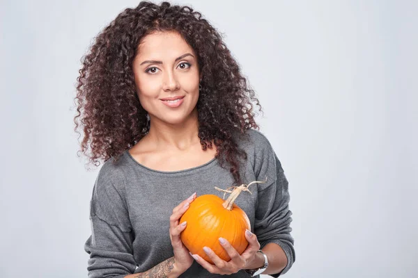 Smiling woman holding ripe pumpkins — Stock Photo, Image