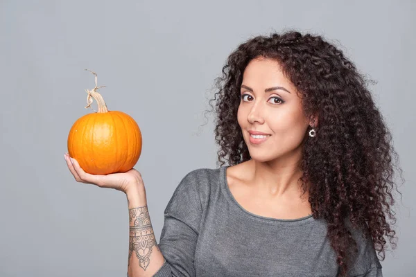 Smiling woman holding ripe pumpkins — Stock Photo, Image