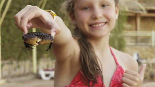 Happy girl holding showing a crab on a beach — Stock Video