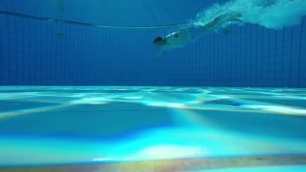 Подводный вид мужчины, плавающего в бассейне — стоковое видео