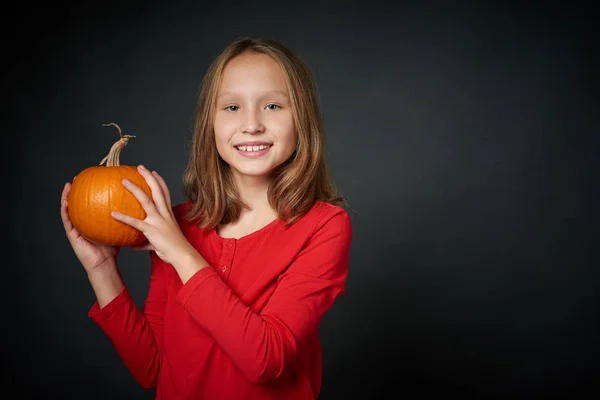 stock image Smiling girl holding ripe pumpkin looking at camera